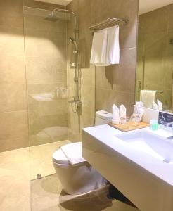 y baño con lavabo, aseo y ducha. en The Henry Hotel Roost Bacolod en Bacolod