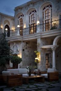 於爾居普的住宿－薩科里德之家酒店，一座大型石头建筑,在庭院里配有沙发