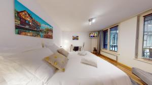 a white bedroom with a large white bed at Studio Coeur de Strasbourg in Strasbourg