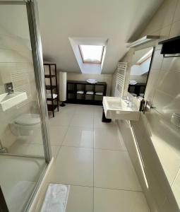 een badkamer met een douche, een wastafel en een toilet bij Malta Premium in Poznań