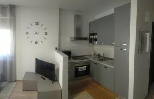 a kitchen with a clock on the wall and a tv at Casa BRUMANA in Tirano