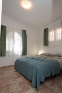 a bedroom with a large bed with green curtains at Wohnung Aulaga in Agüimes