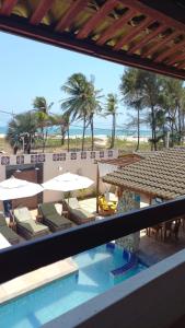 uma vista para a praia a partir da varanda de um resort em Pousada Lua Vermelha em Caponga