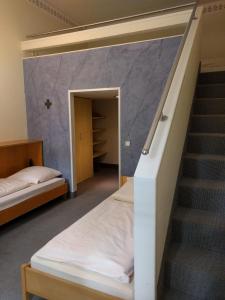 a bedroom with a bunk bed and a staircase at Tagungshaus Reimlingen in Reimlingen