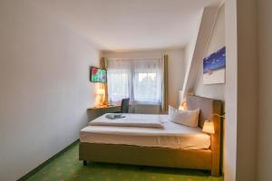 mały pokój z łóżkiem z oknem w obiekcie Hotel & Restaurant Zur Zwiebel w mieście Peenemünde