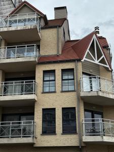 una casa con balcones y techo rojo en Nobel en Middelkerke