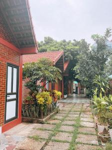 een gebouw van rode baksteen met een binnenplaats met planten bij Chu Thuong Bungalow in Ninh Binh