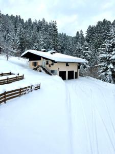 a snow covered yard with a house in the background at Sunnseit Lodge - Kitzbüheler Alpen in Sankt Johann in Tirol