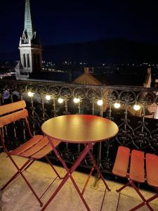 stół i krzesła na balkonie w nocy w obiekcie Studio cosy, hyper centre d'Aix, vue montagnes, proche thermes w Aix-les-Bains
