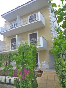 a yellow building with a balcony and flowers at FLORA STUDIOS CORFU - Adults only in Benitses