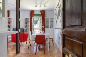 uma sala de jantar com uma mesa branca e cadeiras vermelhas em Confortable piso 3 habitaciones en Retiro Atocha em Madri