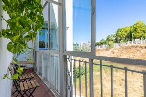 einen Balkon mit einem Fenster und Blick auf ein Feld in der Unterkunft Confortable piso 3 habitaciones en Retiro Atocha in Madrid