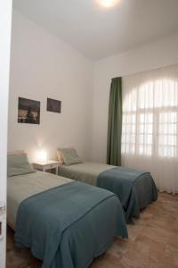 sypialnia z 2 łóżkami i oknem w obiekcie Cardón w mieście Agüimes