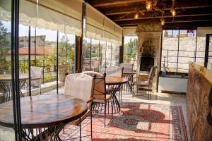 a room with tables and chairs and a fireplace at Efendi Cave Hotel in Urgup