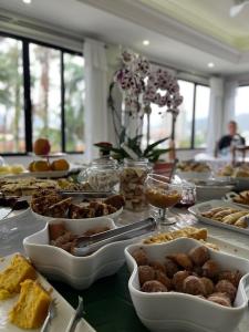 uma mesa com muitos pratos de comida em Arco do Sol Park Hotel em Camboriú