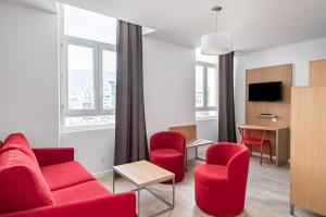 una sala de estar con muebles y ventanas de color rojo. en Residhotel Le Central'Gare, en Grenoble