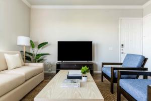 a living room with a couch and a tv at Bright and Spacious Apartments with Gym and Pool Access at Century Stone Hill North in Pflugerville, Austin in Pflugerville