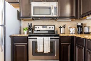 a kitchen with a stove and a microwave at Bright and Spacious Apartments with Gym and Pool Access at Century Stone Hill North in Pflugerville, Austin in Pflugerville +9 photos