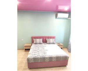 - une chambre avec un lit et un mur violet dans l'établissement Cozy apartments near metro Poznyaki, à Kiev