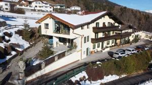 a large house with cars parked in front of it at Landhaus Töchterle in Telfes im Stubai