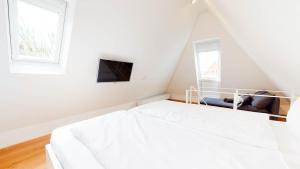 a white bed in a room with two windows at Ankerhaus Ankerhaus 4 in Hörnum +4 photos
