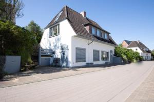 a white house with a black roof on a street at Ankerhaus Ankerhaus 4 in Hörnum