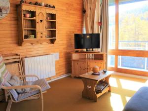 a living room with a television on a wooden wall at Appartement Vars, 3 pièces, 6 personnes - FR-1-330B-33 in Vars