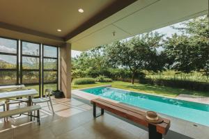 a swimming pool in a house with a large window at twoDO KhaoYai in Mu Si