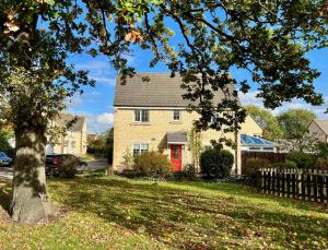 a house with a red door in a yard at Comfortable 3 bedroomed house in Bicester in Bicester