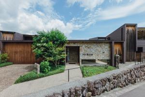 别府SEKIYA RESORT Terrace Midoubaru的享有带石墙的房屋的外部景色