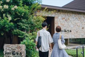 Un homme et une femme se promènent dans un bâtiment dans l'établissement Terrace Midoubaru, à Beppu