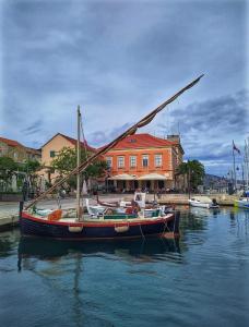 un barco sentado en el agua frente a un edificio en House Beatrix, en Stari Grad