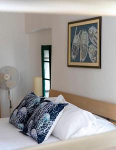 a bed with a pillow and a picture on the wall at House Beatrix in Stari Grad