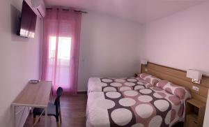 a bedroom with a bed and a table and a desk at ALOJAMIENTOS AGAVE in Tabernas