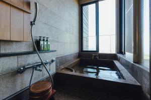 a bathroom with a bath tub with a shower at SEKIYA RESORT Terrace Midoubaru in Beppu +72 photos