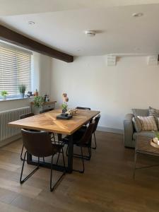 a dining room with a wooden table and chairs at Grade II Listed 3 Bedroom Cottage With Free Parking in King's Lynn