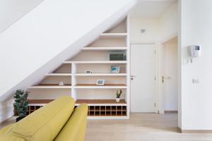 ein gelbes Sofa im Wohnzimmer unter der Treppe in der Unterkunft Home2Book La Casita del Mercado in Santa Cruz de Tenerife + 38 Fotos