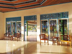een kamer met stoelen, tafels en ramen bij Capital O 91806 Hotel Batu Suli in Palangkaraya