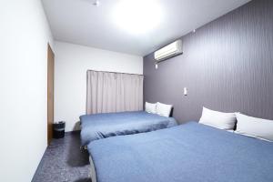 een hotelkamer met 2 bedden en een raam bij NY Cottage A in Tokyo