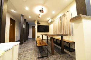 een kamer met een houten tafel en een televisie bij NY Cottage A in Tokyo