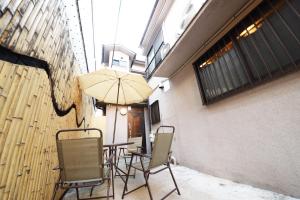 - une table avec des chaises et un parasol dans la chambre dans l'établissement NY Cottage A, à Tokyo