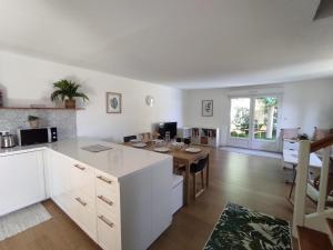 a kitchen with white cabinets and a wooden table at Villa Spa Béziers 4 étoiles ressourcez-vous avec style in Béziers