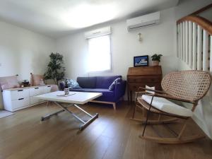 een woonkamer met een blauwe bank en een tafel bij Villa Spa Béziers 4 étoiles ressourcez-vous avec style in Béziers