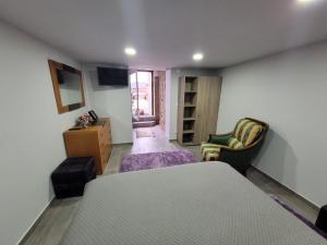 Zimmer mit einem Bett, einem Stuhl und einem Tisch in der Unterkunft Sossego da Laurinda in Vila Praia de Âncora