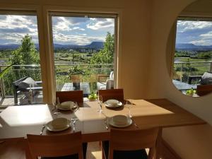 a dining room with a table and a large window at Spacious Fornebu apartment near the sea in Fornebu