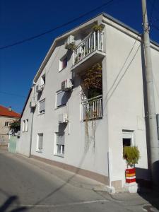 a white building with a balcony on the side of it at Biba in Mostar