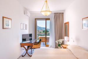 a bedroom with a bed and a desk and a computer at HOTEL ZI'NTONIO in Scala