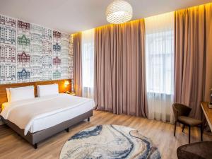 Un dormitorio con una gran cama blanca y una ventana en Mercure Riga Centre en Riga