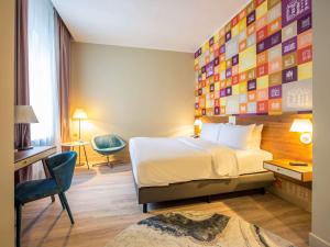 a hotel room with a bed and a wall of squares at Mercure Riga Centre in Rīga