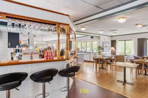a restaurant with a bar with chairs and tables at Best Western Hotell SoderH in Söderhamn